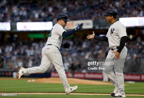 Jose Trevino of the New York Yankees is congratulated by third base coach Luis Rojas after Trevino hit a solo home run in the third inning against...