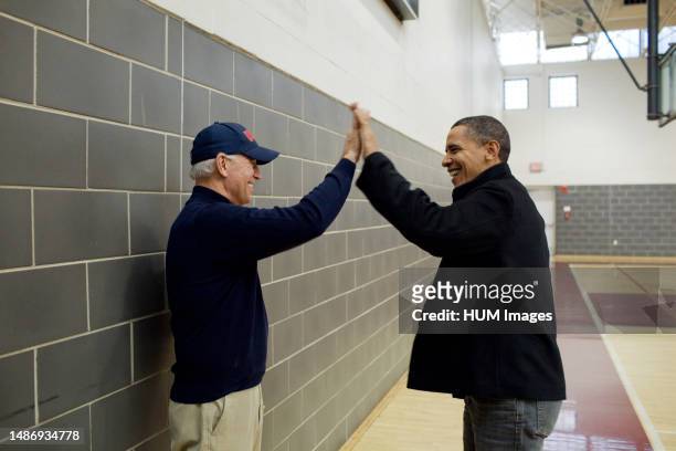 President Barack Obama and Vice President Joe Biden high-five after watching Sasha Obama and Maisy Biden play in a basketball game in Chevy Chase,...