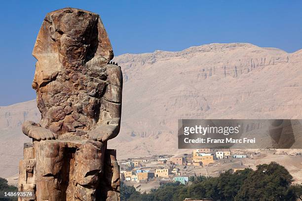 one of the two colossi of memnon on the westbank of luxor, ancient thebes. - colossi of memnon stock pictures, royalty-free photos & images