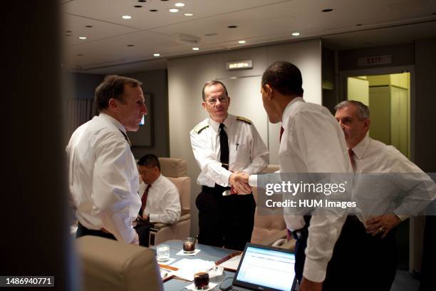 President Barack Obama shakes hands with Admiral Michael Mullen, chairman of the Joint Chiefs of Staff, aboard Air Force One en route to Washington,...
