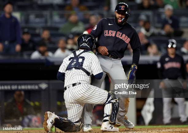 Amed Rosario of the Cleveland Guardians celebrates after he scored in the ninth inning as Jose Trevino of the New York Yankees is unable to make the...