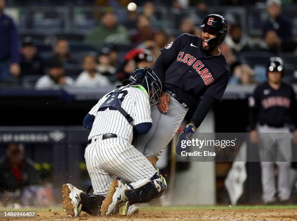 Amed Rosario of the Cleveland Guardians celebrates after he scored in the ninth inning as Jose Trevino of the New York Yankees is unable to make the...