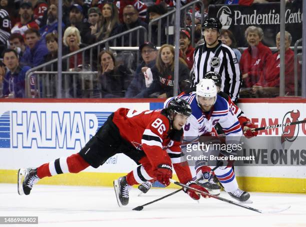Jack Hughes of the New Jersey Devils is tripped up by Jacob Trouba of the New York Rangers during the second period in Game Seven of the First Round...