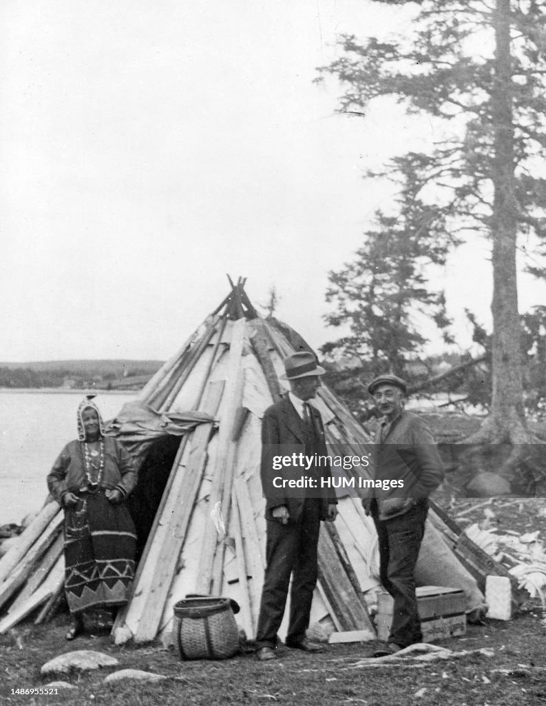 Birch-bark summer 'camp' or wigwam of Micmac Indian, Henry Sack (son of Isaac Sack) and his wife Susan (in typical old Micmac woman's costume) on Indian Point, Fox Point Road, near Hubbards, Lun. Co., N.S. ca. 1935