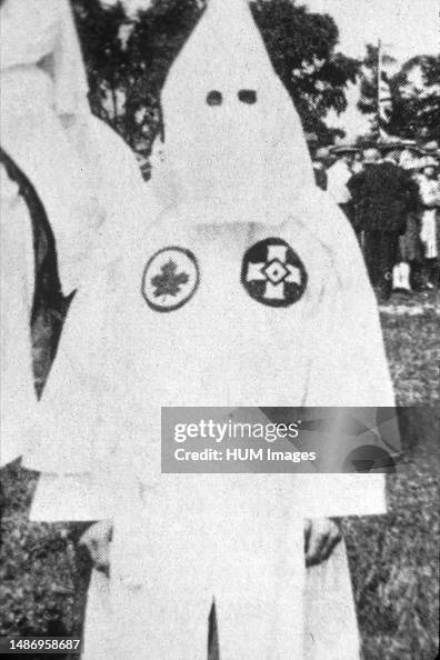 Image of a man in a hood and robe - In late 1926 Klan organizers entered Saskatchewan. - Close up of Canadian Klansman in full regalia, Kingston, Ontario, July 1, 1927. Note the maple leaf symbol on the left side of the Klansman's chest