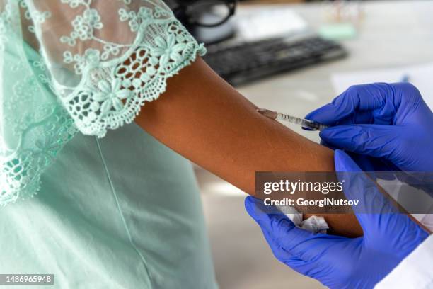 a female pediatrician examines a child and administers the mandatory vaccines. - administers stock pictures, royalty-free photos & images