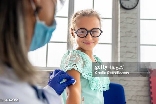 a female pediatrician examines a child and administers the mandatory vaccines. - administers stock pictures, royalty-free photos & images