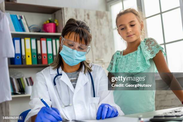 a female pediatrician examines a child and administers the mandatory vaccines. - administers stock pictures, royalty-free photos & images