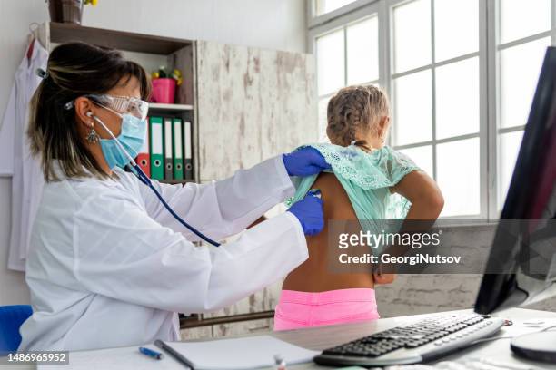 a female pediatrician examines a child and administers the mandatory vaccines. - administers stock pictures, royalty-free photos & images