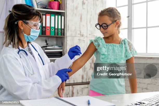 a female pediatrician examines a child and administers the mandatory vaccines. - administers stock pictures, royalty-free photos & images