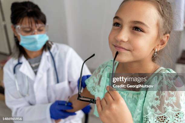 a female pediatrician examines a child and administers the mandatory vaccines. - administers stock pictures, royalty-free photos & images