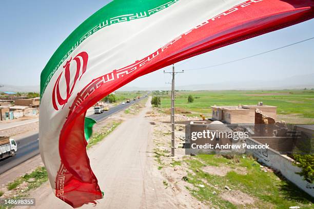 iranian flag on pedestrian overpass on highway 16 between sarab and nir. - iranian flag stock-fotos und bilder