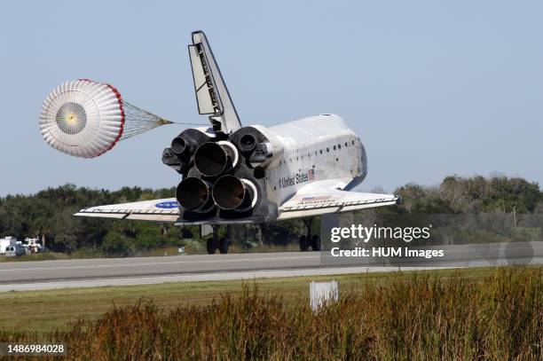 With drag chute unfurled, space shuttle Atlantis lands on Runway 33 at the Shuttle Landing Facility at NASA's Kennedy Space Center in Florida after...