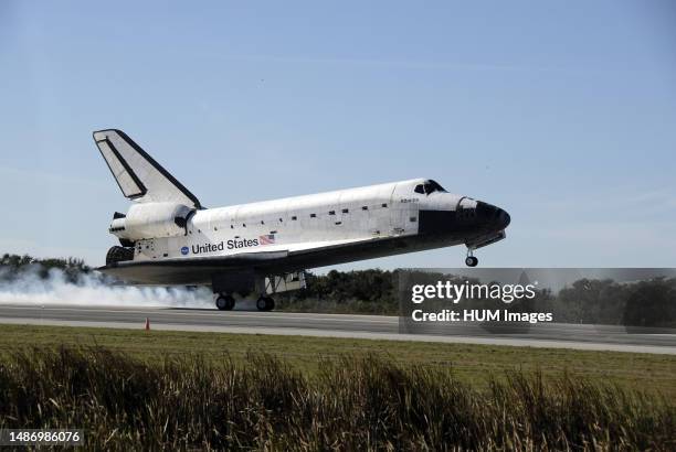 Space shuttle Atlantis kicks up dust as it touches down on Runway 33 at the Shuttle Landing Facility at NASA's Kennedy Space Center in Florida after...