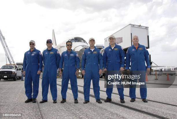 Members of the STS-119 crew pose for a group portrait in front of space shuttle Discovery on Runway 15 at NASA's Kennedy Space Center in Florida,...