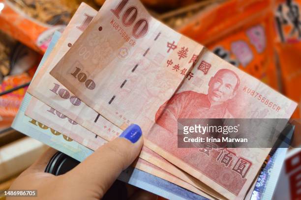 paying with new taiwan dollar - taiwanese currency stock pictures, royalty-free photos & images