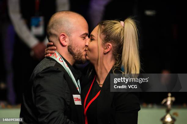 Luca Brecel of Belgium kisses his girlfriend after winning the final match against Mark Selby of England on day 17 of the 2023 Cazoo World...