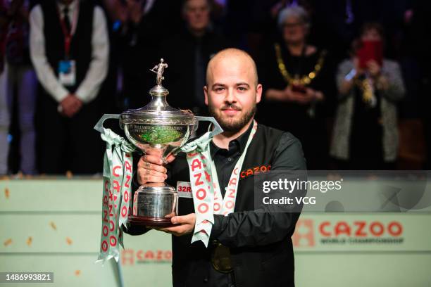 Luca Brecel of Belgium holds the trophy after winning the final match against Mark Selby of England on day 17 of the 2023 Cazoo World Championship at...