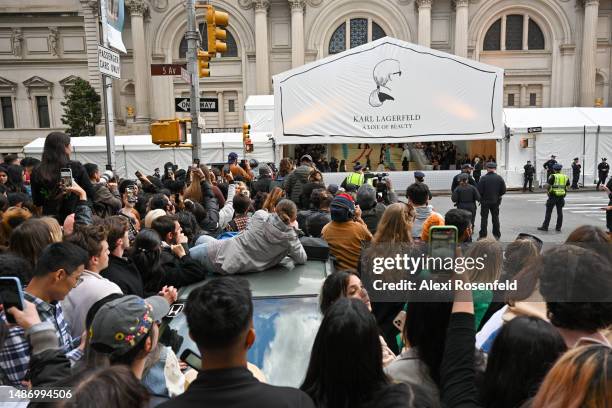 Fans gather and climb on cars to catch a glimpse of the attendees of The 2023 Met Gala Celebrating "Karl Lagerfeld: A Line Of Beauty" at The...