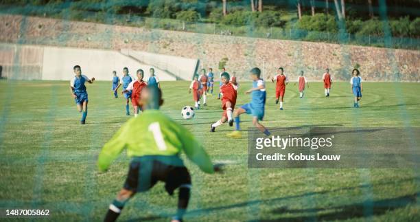 kids, team and playing football on field, sport and exercise, group of people outdoor during game. teamwork, fitness and athlete children, goal keeper and soccer players on sports ground with action - pro challenge stage 6 stock pictures, royalty-free photos & images