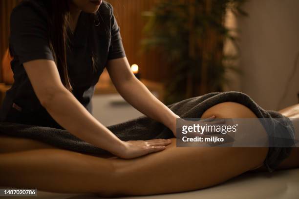 woman receiving leg massage in spa center - women buttocks stock pictures, royalty-free photos & images