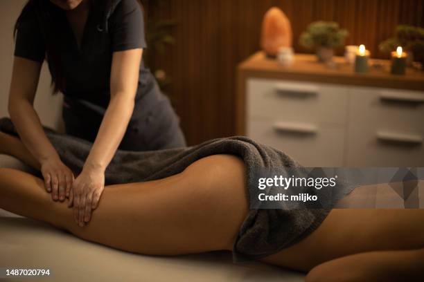 woman receiving leg massage in spa center - spagat stockfoto's en -beelden