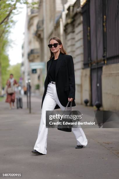 Diane Batoukina wears black sunglasses, a black ribbed halter neck tank-top, a black blazer jacket from Zara, a black shiny leather small Kelly belt...