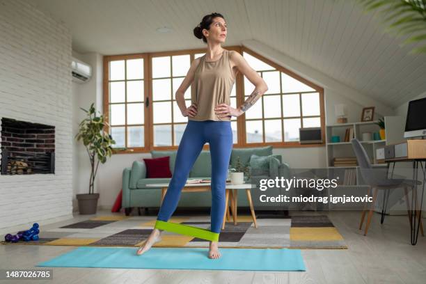 woman exercising with a strap at home - resistance band stock pictures, royalty-free photos & images