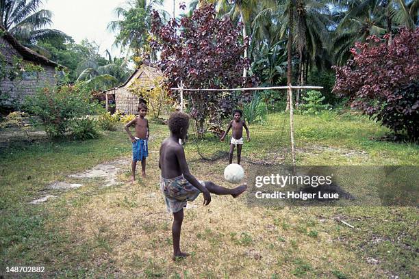 young boys playing soccer in yard. - solomon islands stock pictures, royalty-free photos & images