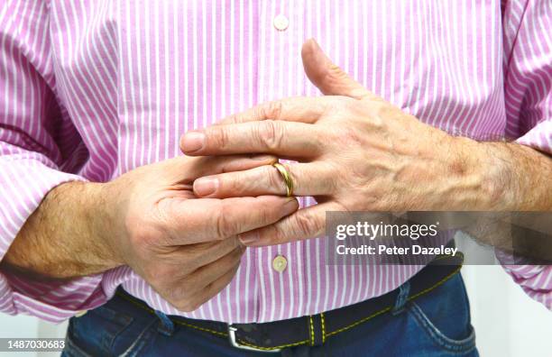 man taking off wedding ring - unrequited love stock pictures, royalty-free photos & images