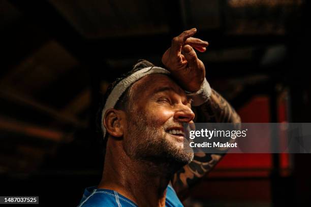 tired male athlete wiping sweat from forehead at sports court - sueur photos et images de collection