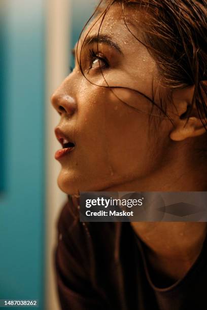 female athlete with sweat on face looking away in locker room - locker room stock pictures, royalty-free photos & images