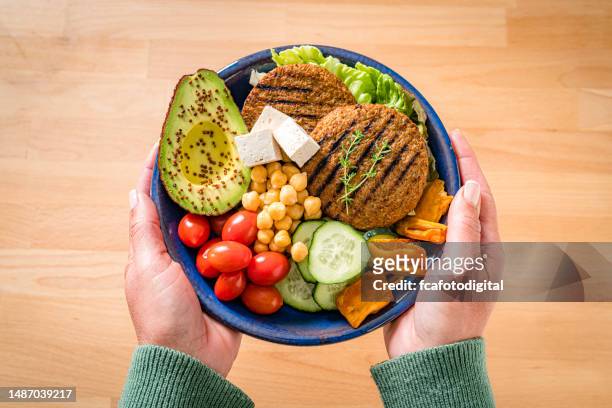 la donna tiene un piatto con cibo sano a base vegetale - seitan foto e immagini stock