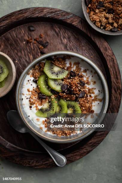 breakfast chocolate granola yogurt bowl with kiwi fruits - kiwi fruit stock pictures, royalty-free photos & images