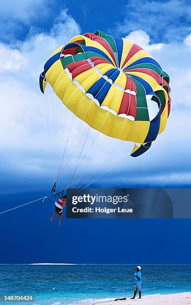 parasailing at the beach. - beachcomber island stock pictures, royalty-free photos & images