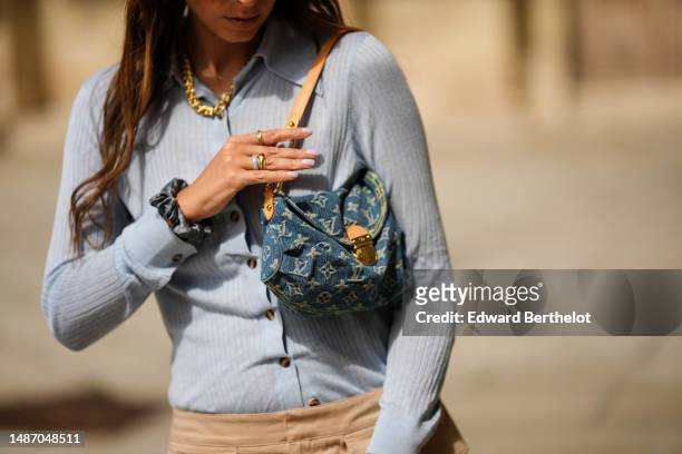 Gabriella Berdugo wears a gold large necklace, a pale blue ribbed wool long sleeves polo shirt from Dodo Baror , a beige micro cargo skirt from from...