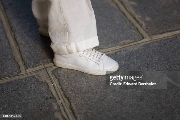 Diane Batoukina wears high waist linen large pants from Ralph Lauren, white shiny leather sneakers, during a street style fashion photo session, on...
