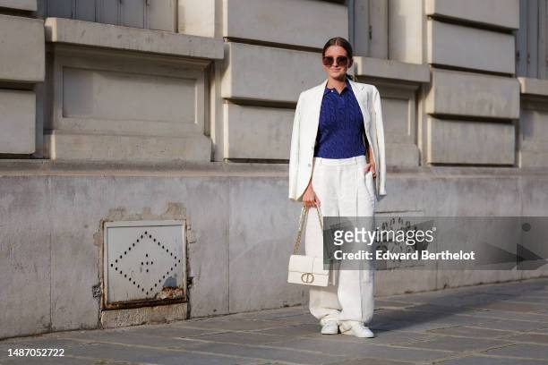 Diane Batoukina wears dark brown large squared sunglasses from Dior, a navy blue braided wool short sleeves polo shirt from Ralph Lauren, high waist...