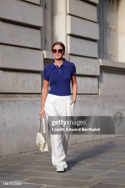 Diane Batoukina wears dark brown large squared sunglasses from Dior, a navy blue braided wool short sleeves polo shirt from Ralph Lauren, high waist...