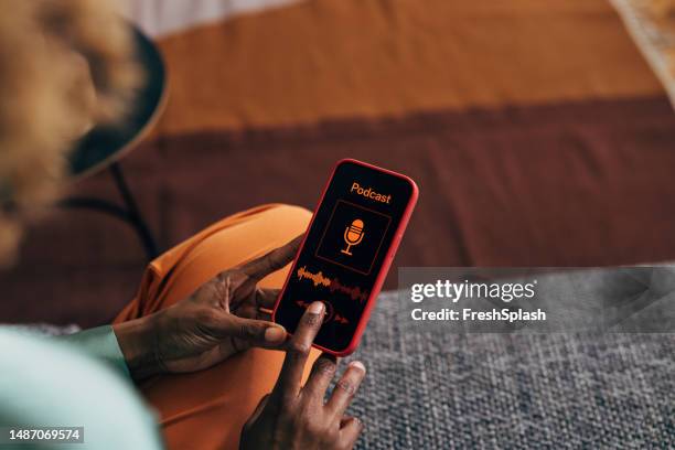 eine nicht wiederzuerkennende frau, die ihr mobiltelefon benutzt - podcasting stock-fotos und bilder