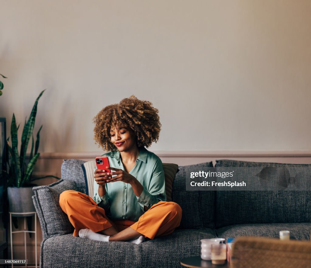 A Happy Beautiful Woman Texting On Her Mobile Phone While Relaxi