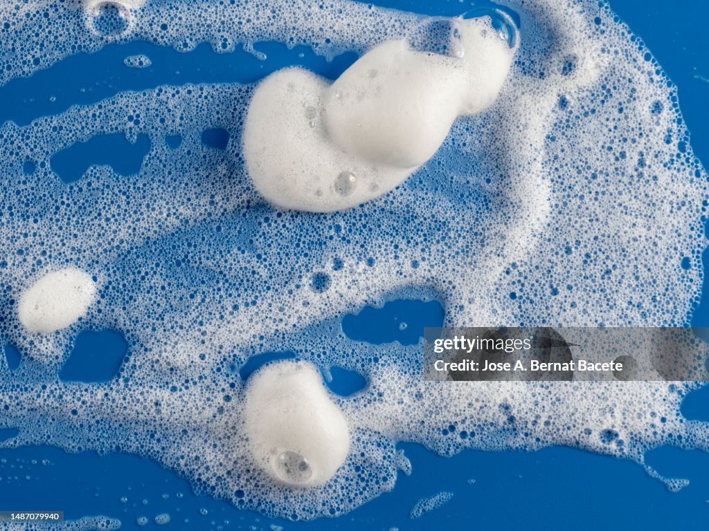 Foam and soap bubbles in the bathroom on a blue background.