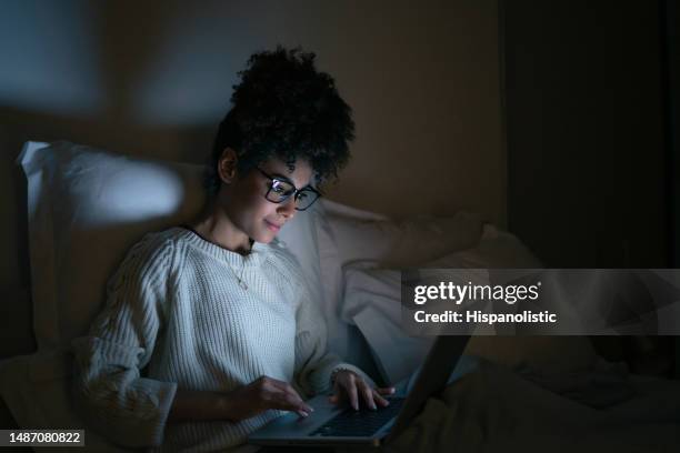 woman working late at a home in bed and using her laptop - authors night 個照片及圖片檔