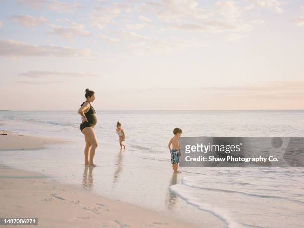 soon to be mother of 3 contemplating at sunset - beach florida family stockfoto's en -beelden