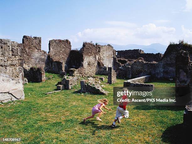 boy and girl playing among roman ruins. - pompeii stock pictures, royalty-free photos & images