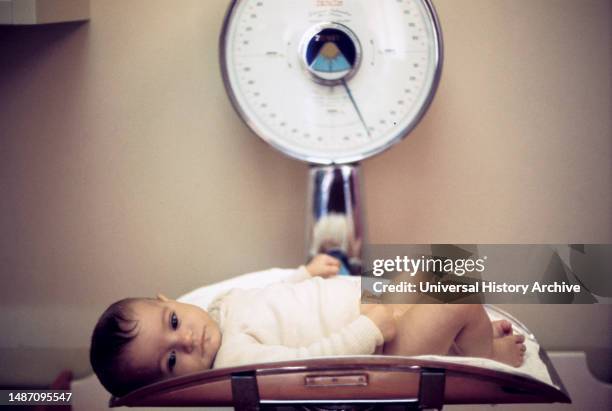 Newborn on a balance, 70's.