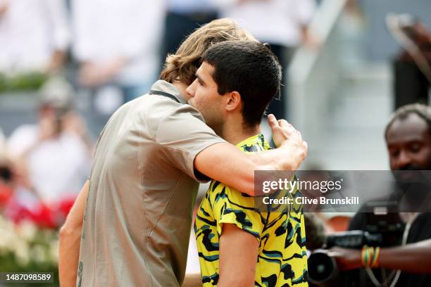 Alexander Zverev of Germany and Carlos Alcaraz of Spain interact at the net following the Fourth Round match on Day Nine of the Mutua Madrid Open at...