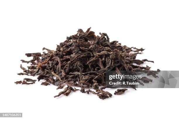 black dry tea leaves isolated on white background - feuilles-de-thé-séchées photos et images de collection