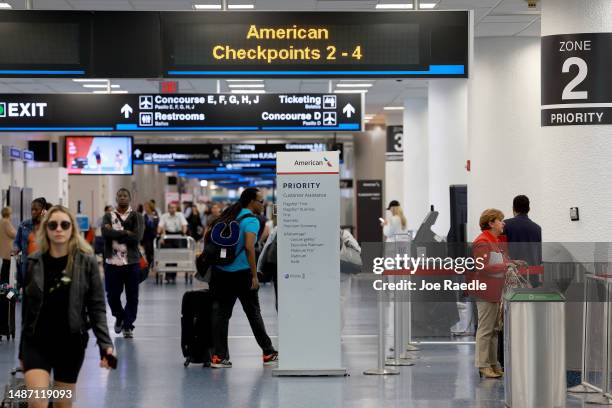 Travelers walk past the American Airline ticketing area at the Miami International Airport on May 02, 2023 in Miami, Florida. American Airlines...