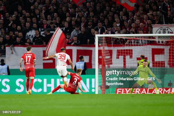 Benjamin Henrichs of Leipzig scores his team's second goal against Philipp Lienhart of Freiburg during the DFB Cup semifinal match between Sport-Club...